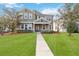 Two-story house with green siding, stone accents, and a manicured lawn at 1942 J Lawson Blvd, Orlando, FL 32824