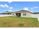 This is an exterior view of the backyard featuring the grass, fence, and patio area at 2249 Palmetum Loop, Apopka, FL 32712
