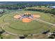 Aerial view of well-maintained baseball fields with green grass and clay infields surrounded by lush trees at 2249 Palmetum Loop, Apopka, FL 32712