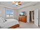 Bright bedroom featuring tray ceilings, a ceiling fan, and an en-suite bathroom with a modern sliding door at 2249 Palmetum Loop, Apopka, FL 32712