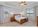 Inviting bedroom featuring ample natural light, tray ceilings, a ceiling fan, and neutral wall paint at 2249 Palmetum Loop, Apopka, FL 32712