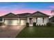 Charming single-story home featuring a three-car garage, lush landscaping, and a neatly manicured lawn at 2249 Palmetum Loop, Apopka, FL 32712