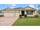 Charming single-story home with a well-manicured lawn, brick driveway and a two car garage at 2249 Palmetum Loop, Apopka, FL 32712