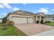 Beautiful single-story home with a three-car garage, brick-paved driveway, and manicured front lawn at 2249 Palmetum Loop, Apopka, FL 32712