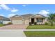 Well-maintained single-story home boasting a three-car garage, and lush lawn with mature landscaping at 2249 Palmetum Loop, Apopka, FL 32712