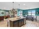 Spacious eat-in kitchen with a granite island, stainless steel appliances, and views of the living room and dining area at 2249 Palmetum Loop, Apopka, FL 32712