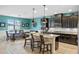 A modern, stylish kitchen featuring black cabinets, granite counters, and an island at 2249 Palmetum Loop, Apopka, FL 32712