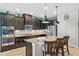 Stylish kitchen featuring dark cabinets, granite countertops, stainless steel appliances and modern pendant lighting at 2249 Palmetum Loop, Apopka, FL 32712