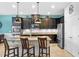 Stylish kitchen featuring dark cabinetry, granite countertops, stainless steel appliances, and an island with seating at 2249 Palmetum Loop, Apopka, FL 32712