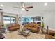 This is an interior view of the living room with leather sofas, decorative rug, and ceiling fan at 2249 Palmetum Loop, Apopka, FL 32712