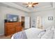 Bright main bedroom with tray ceiling, dresser, and ensuite bath access at 2249 Palmetum Loop, Apopka, FL 32712