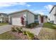 Single-story home with gray siding, red door, and paver driveway at 2322 Twin Flower Ln, Sanford, FL 32771