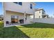 Covered patio, grassy yard, and grill at 242 Aberdeen St, Davenport, FL 33896
