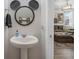 This half-bathroom boasts a unique Mickey Mouse mirror and stylish pedestal sink at 242 Aberdeen St, Davenport, FL 33896
