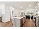 Open concept kitchen features island, stainless steel appliances, and wood-look flooring at 2592 Kinsale Ln, Ormond Beach, FL 32174