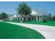 White clubhouse with green roof and landscaping at 2913 Hudson Hammock Way, Saint Cloud, FL 34773