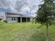 Expansive backyard featuring a covered patio, lush green grass, and a young tree, ideal for outdoor enjoyment at 4535 Gliding Wave St, Winter Garden, FL 34787