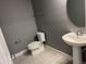 Simple half bathroom featuring a gray wall paint, pedestal sink, and a classic toilet at 4535 Gliding Wave St, Winter Garden, FL 34787