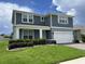 Beautiful two-story home with a well-manicured lawn, a two car garage, and blue and gray siding at 4535 Gliding Wave St, Winter Garden, FL 34787