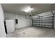 Attached two car garage with opener, refrigerator and white walls at 4535 Gliding Wave St, Winter Garden, FL 34787