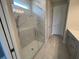 Bathroom with a glass-enclosed shower featuring marble tile and stylish hardware at 4535 Gliding Wave St, Winter Garden, FL 34787
