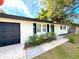 Updated home with white brick exterior, black garage door, and green front door at 4732 Lighthouse Cir, Orlando, FL 32808