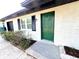 Front entrance of a renovated home with a green door and white brick at 4732 Lighthouse Cir, Orlando, FL 32808