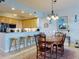 Elegant dining room with wood table and chairs, and views into the kitchen at 5 Riverwalk Dr # 503, New Smyrna Beach, FL 32169
