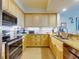 Bright kitchen with light wood cabinets, granite counters, and stainless steel appliances at 5 Riverwalk Dr # 503, New Smyrna Beach, FL 32169
