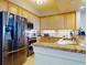 Condo kitchen with granite counters, modern appliances, and wood cabinets at 5 Riverwalk Dr # 503, New Smyrna Beach, FL 32169