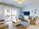 Living room with wicker chairs, a large TV and scenic water views at 5 Riverwalk Dr # 503, New Smyrna Beach, FL 32169