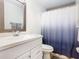 Bathroom with white vanity, toilet and blue shower curtain at 5003 Laguna Bay Cir # 16, Kissimmee, FL 34746