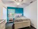 Bedroom with white bed frame, teal accent wall, and ceiling fan at 5003 Laguna Bay Cir # 16, Kissimmee, FL 34746