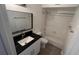 White bathroom with a large vanity mirror, black granite countertop, and a shower-tub combo at 5587 Devonbriar Way # 104, Orlando, FL 32822