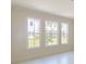 Bright bedroom showcasing three large windows offering backyard views and natural light at 9819 Gobat Aly, Orlando, FL 32827