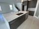 A kitchen featuring a marble island, stainless steel faucet, and dark wood cabinets at 9819 Gobat Aly, Orlando, FL 32827