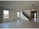 An airy living room with lots of light, showcasing the staircase and open floor plan at 9819 Gobat Aly, Orlando, FL 32827