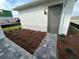 New construction featuring a gray side entrance door, brick paver walkway, and freshly mulched landscaping at 9819 Gobat Aly, Orlando, FL 32827