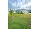 Landscaped front yard with a palm tree and spacious green grass at 1107 Tropea Ln, Auburndale, FL 33823