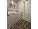 Convenient laundry room with washer, dryer, and overhead shelving at 1107 Tropea Ln, Auburndale, FL 33823
