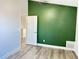 Bright bedroom with green accent wall and wood-look flooring at 12061 Greco Dr, Orlando, FL 32824