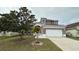 Two-story house with attached garage and landscaping at 12061 Greco Dr, Orlando, FL 32824