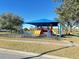 Community playground with shade structure and swings at 12061 Greco Dr, Orlando, FL 32824