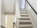 Modern staircase with gray wood-look treads and a black railing at 12061 Greco Dr, Orlando, FL 32824