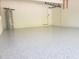 Spacious garage with painted walls, speckled flooring, and a hot water heater at 1624 Valmont Ln, Apopka, FL 32703