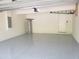 Clean and spacious garage featuring epoxy flooring, with water heater, and door to outside at 1624 Valmont Ln, Apopka, FL 32703