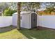 Backyard featuring a clean storage shed in a well-maintained yard, secured with a white fence at 1624 Valmont Ln, Apopka, FL 32703