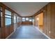 Sunroom with wood paneling, new flooring, and windows at 217 Bentbough Dr, Leesburg, FL 34748