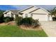Tan house with double garage and landscaping at 2530 Saffron Ln, The Villages, FL 32162
