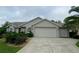 Tan house with double garage and manicured landscaping at 2530 Saffron Ln, The Villages, FL 32162